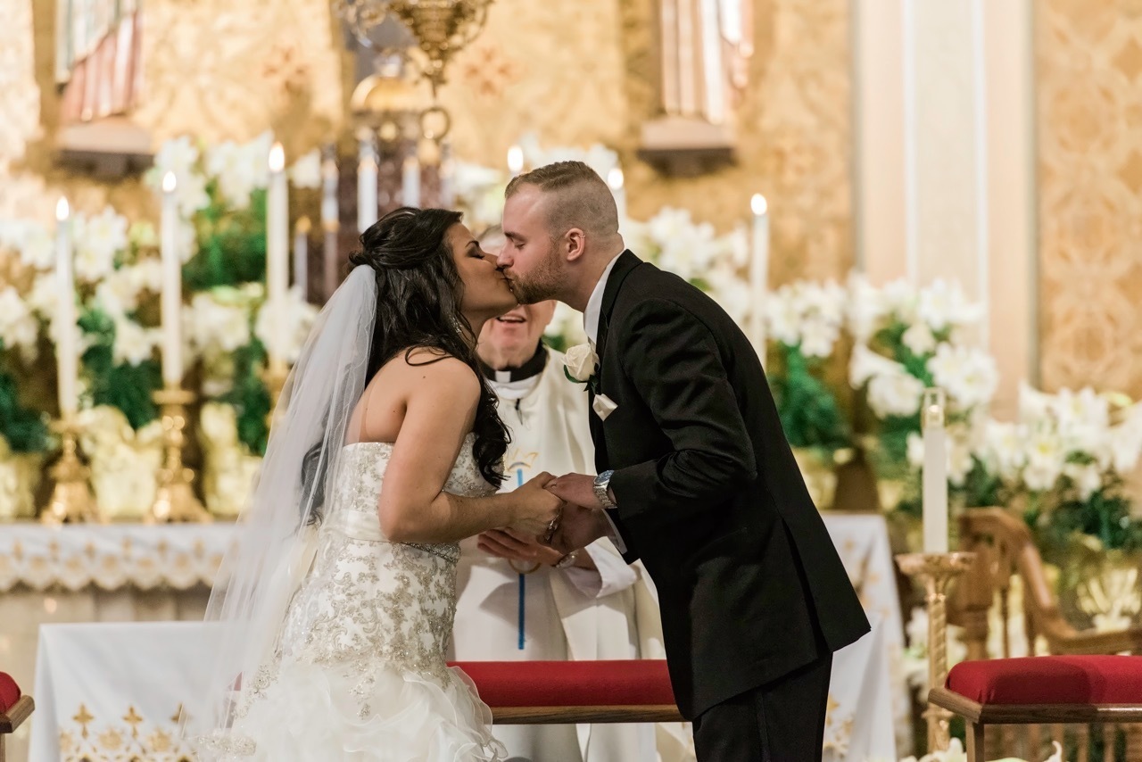 A first kiss between a bride and groom